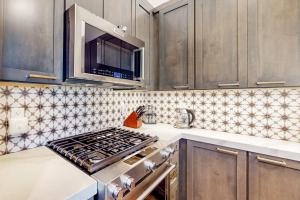 a kitchen with a stove and a microwave at Ski and Ski Out Designer Condo With a View in Kingswood Estates
