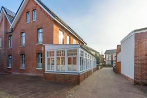 a brick building with a conservatory on the side of it at Woge2 Appartement 1 in Borkum