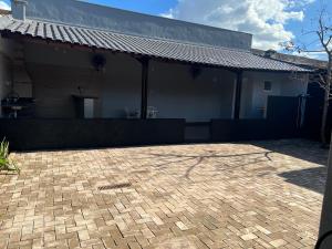 a house with a brick driveway in front of it at Casa com área de lazer tranquila e espaçosa! in Campo Grande