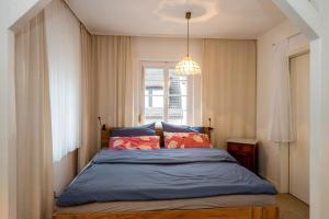 a bedroom with a bed with blue sheets and a window at Frankfurter Haus in Zell an der Mosel