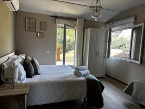 a bedroom with a bed and a large window at Finca Avellaneda in Navahonda