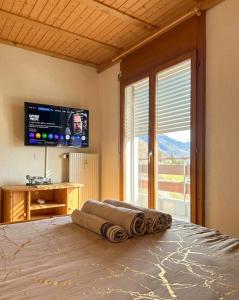 a bedroom with a bed with a flat screen tv at Duplex lumineux avec vue in Vionnaz