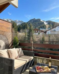 a patio with a couch and glasses of wine at Duplex lumineux avec vue in Vionnaz