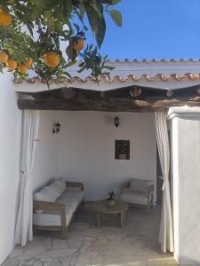 a porch with a couch and an orange tree at Can Joan Yern in Sant Joan de Labritja