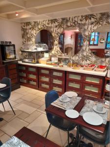 a kitchen with a table and a counter with food at Manoir Du Cunningham in Saint Malo