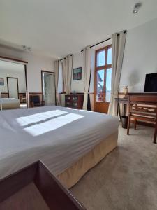 a large bedroom with a large bed and a piano at Manoir Du Cunningham in Saint Malo
