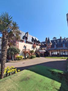 a large house with a palm tree in front of it at Manoir Du Cunningham in Saint Malo