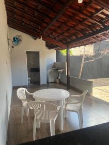 a white table and chairs on a patio at Casa com área de lazer tranquila e espaçosa! in Campo Grande
