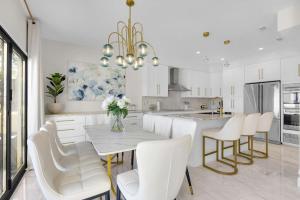 a white kitchen with a table and white chairs at Buena Vida 22 - A in Navarre