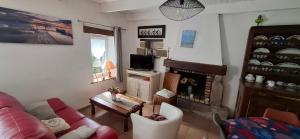 a living room with a couch and a fireplace at Ty Coz in Saint-Ségal