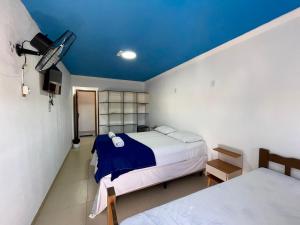 a bedroom with a bed and a blue ceiling at Pousada Bellmar Peró - Praia e Comércio 8 min andando in Cabo Frio