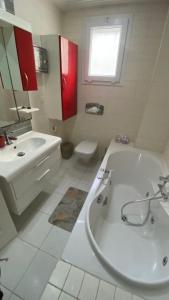 a white bathroom with a tub and a sink at SunWave Chott Meriem in Sousse +15 photos