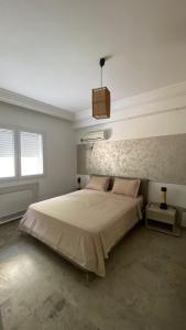 a bedroom with a large bed in a white room at SunWave Chott Meriem in Sousse