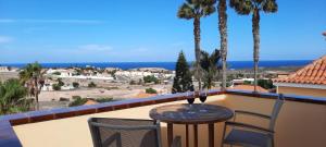 a table with two glasses of wine on a balcony at Casa Panorama in La Pared