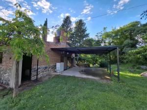 a covered patio in front of a brick building at Casa en El Rodeo in El Rodeo