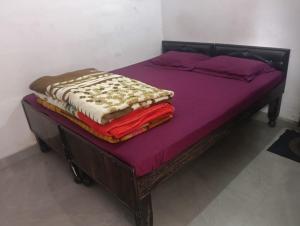 a bed with purple sheets and blankets on it at Hotel Himalayan dews in Ukhimath