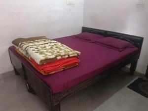 a bed with purple sheets and blankets on it at Hotel Himalayan dews in Ukhimath