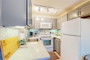 a kitchen with white cabinets and a white refrigerator at Tranquil condo in Stateline sleeps 4 in Stateline