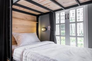 Un dormitorio con una cama y una ventana grande en X9Hostel, en Bangkok