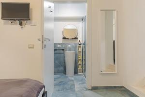 a room with a bed and a mirror and a tv at L'Acqua e la Pietra in Rapolano Terme