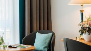 a table with a chair and a table with a pillow at Dorint Hotel Dresden in Dresden