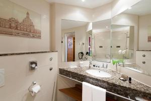 a bathroom with a sink and a large mirror at Dorint Hotel Dresden in Dresden