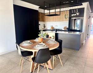 a kitchen with a wooden table and black chairs at Stylish Industrial City Retreat in Bowden