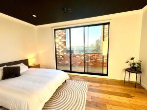a bedroom with a bed and a large window at Stylish Industrial City Retreat in Bowden