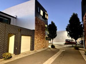 a brick building with two garage doors on a street at Stylish Industrial City Retreat in Bowden