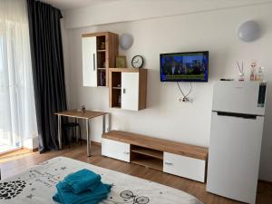a kitchen with a white refrigerator and a table at BLAXY Resort STEFI in Douăzeci şi Trei August