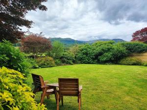 two chairs and a table in a grassy yard at Springfield House in Grasmere