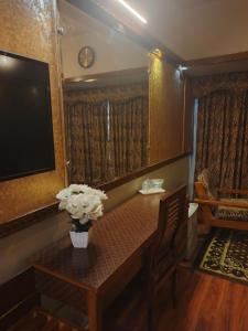 a room with a table with a vase of flowers on it at Faran Hotel in Karachi