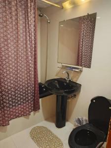 a bathroom with a sink and a toilet and a mirror at Faran Hotel in Karachi