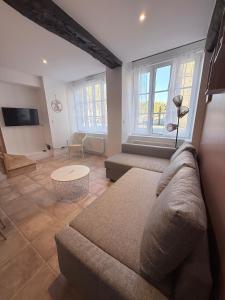 a living room with a couch and a tv at Le Cocon - Vue sur le Port de DINAN - Parking privé in Lanvallay
