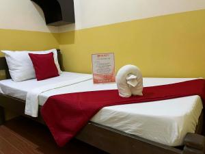 two beds in a hotel room with a towel on them at RTRoss Hotel in Masbate