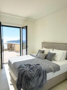 a bedroom with a large bed with a large window at Iris in Radovici
