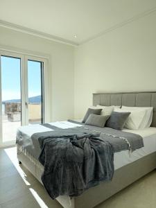 a white bedroom with a large bed and a window at Iris in Radovici +7 photos