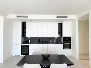 a kitchen with a black table and white cabinets at Iris in Radovici