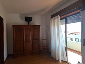 a living room with a sliding glass door with a television at Residência Livramento in Velas