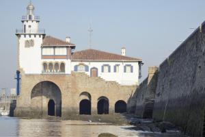 a building with a clock tower next to a river at Pensión Basagoiti in Getxo +26 photos
