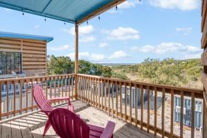 two chairs on a deck with a view of the ocean at The Container Retreat - 4B.. in Canyon Lake
