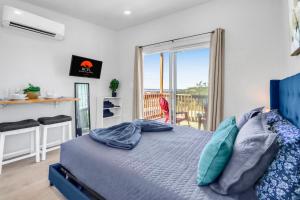 a bedroom with a blue bed and a balcony at The Container Retreat - 4B.. in Canyon Lake