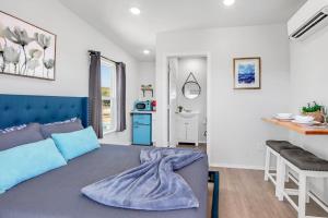 a bedroom with a blue bed and a kitchen at The Container Retreat - 4B.. in Canyon Lake