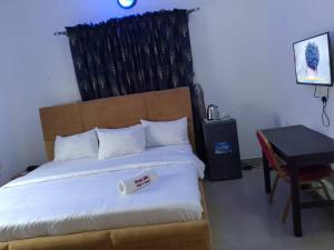 a bedroom with a large bed with a desk and a bed sidx sidx at Classic Hills Hotel & Resort in Uyo