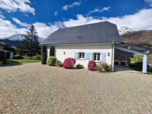 a white house with a gravel driveway at Les hauts de LOUVIE in Louvie-Soubiron