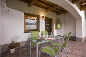 a dining room with a table and green chairs at Ferienwohnung Hauser in Söll