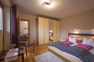 a bedroom with a large bed and a table and a chair at Ferienwohnung Hauser in Söll