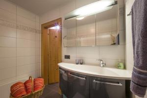 a bathroom with a sink and a mirror at Ferienwohnung Hauser in Söll +21 photos