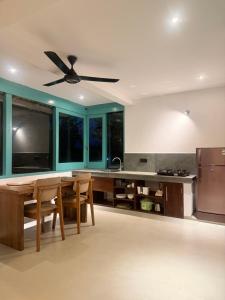 a kitchen with a table and a ceiling fan at casa luna villa in Narigama