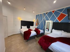 a hotel room with two beds and a painting on the wall at Black & White Guest House in Parow